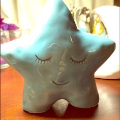 a blue ceramic star with eyes closed on a table