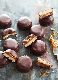 chocolate covered pastries on a table with a knife and some broken ones next to them