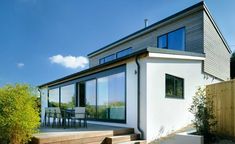 a modern house with large windows and wooden steps leading up to the outside patio area