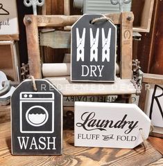 three wooden signs that say laundry, wash and dry on the side of a chair