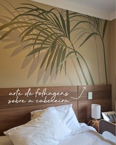 a hotel room with a palm tree painted on the wall and bed in front of it