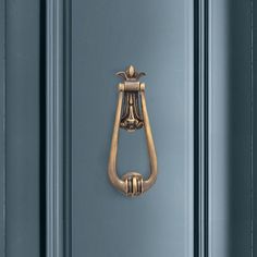 an ornate brass handle on a blue door