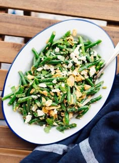 a white plate topped with green beans and feta cheese