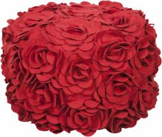 a large red flowered pillow sitting on top of a white floor