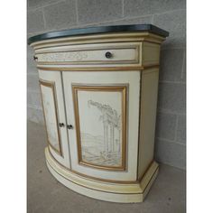 an ornate painted cabinet on display in a room with brick wall and tile flooring