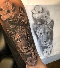 two lions with flowers on their arm, one is black and grey the other is white