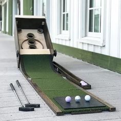 an open box with golf balls and tees laying on the ground