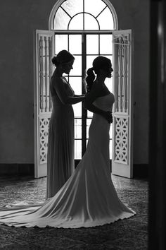 two women standing in front of an open door