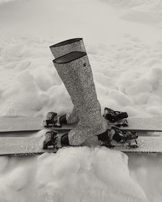 a pair of skis sitting in the snow with their feet propped up on them