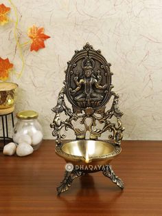 an ornate metal bowl on top of a wooden table