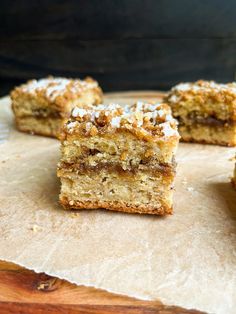 four pieces of cake sitting on top of a wooden cutting board