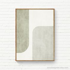 a white brick wall with an abstract painting hanging on it's side next to a wooden frame