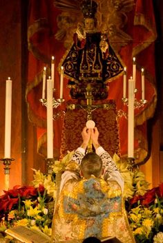 a man kneeling down in front of a alter