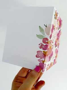 a person holding up a card with flowers on it