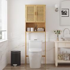 a white toilet sitting in a bathroom next to a sink and a wooden shelf above it