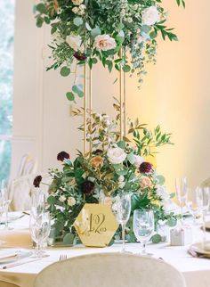 the table is set with flowers and wine glasses