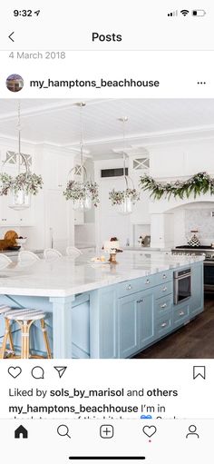 a large kitchen with blue cabinets and white counter tops is decorated with christmas greenery