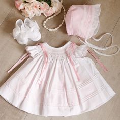 This Little Dress Set Is Most Adorable!! The Set Includes An Heirloom Dress, Slip, Bonnet & Shoes. Smocking, Hand-Embroidery, Satin Ribbons, Pin Tucks And Ruffles Set This Set Apart From The Average Baby Outfit. The Neckline Is Smocked In A Bishop Style And Has Flutter Sleeves That Are Adorned With Pink Dot Embroidery And A Scalloped Embroidered Pink Hem. Embroidered Pink Bullion Buds And Green Leaves Are Super Sweet Atop The Lattice Design Smocking.The Bottom Of The Top Dress Layer Has 8 Row Of Heirloom Bonnet, White Smocked Dress, Baby Pink Clothes, Dot Embroidery, Smocked Bishop Dress, Dinosaur Dress, Heirloom Dresses, Dress Layer, Pink Dot