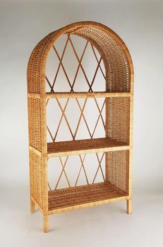 a wicker shelf with three shelves on each side and an arched door at the top