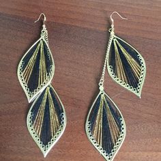 two pairs of earrings on top of a wooden table