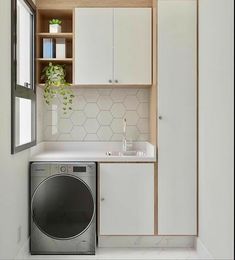 a washer and dryer in a small room with open cabinets on the wall