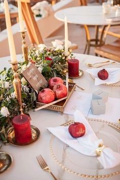 the table is set with candles, apples and other items for an elegant wedding reception