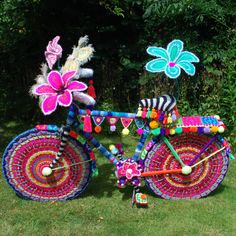 a colorful bicycle decorated with flowers and feathers