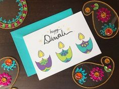 a card with embroidered designs on it and the words happy diwali written in cursive writing