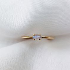 "9k Gold Rainbow Moonstone Ring, Gold Moonstone Ring, Moonstone Engagement Wedding Ring, Simple Moonstone Ring Oval Cabochon Bridal Ring  Beautiful rainbow moonstone ring made with 9k yellow Gold. This 9k delicate ring is set with a 5x3mm oval moonstone on a plain band. This ring would make a perfect anniversary ring, promise ring or birthday gift. Moonstone is the birthstone for June.  Material / Dimensions  Solid 9ct yellow gold Gemstone: Moonstone Band width: 1.2mm Stone: 5x3mm Photos of this ring has been taken close up for detail. Please refer to a ruler for dimensions of stone and band width. Don't forget to hit \"favourite\" on the right, so it remains in your favourites list and/ or add to your wish list(s). -------------------------------------------------------------------------- Gold Ring Moonstone, Dainty Oval Moonstone Promise Ring, Fine Jewelry Oval Moonstone Ring With Rose Cut Diamonds, White Oval Moonstone Ring With Rose Cut Diamonds, Minimalist Oval Cabochon Wedding Jewelry, Oval Moonstone Halo Ring Fine Jewelry, Oval Halo Moonstone Ring Fine Jewelry, Minimalist Oval Birthstone Promise Ring, Minimalist Oval Cabochon Wedding Ring