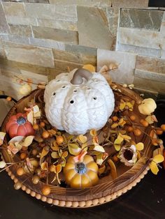 a basket filled with pumpkins and gourds on top of a table