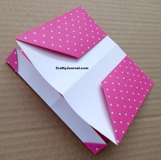 an origami envelope with pink and white polka dots