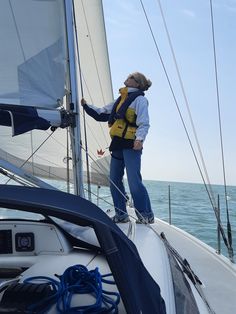 a woman standing on top of a sail boat