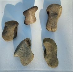 four pieces of rock sitting on top of a white surface