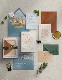 the wedding stationery is laid out on top of each other, including cards and envelopes