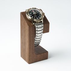 a watch sitting on top of a wooden stand