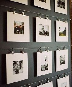 several pictures hanging on a wall with clothes pins