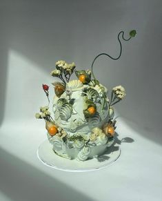 a white cake decorated with flowers and fruit