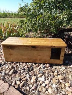 a wooden box sitting on top of a pile of rocks