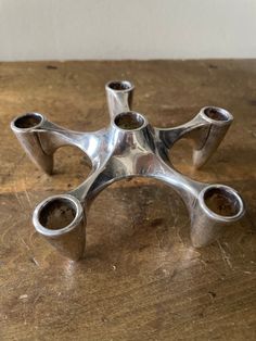 three metal objects sitting on top of a wooden table