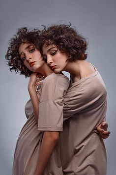 two women are posing for the camera with their arms around each other's shoulders