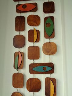 a group of wooden pieces hanging from a wall next to each other with different shapes and colors on them