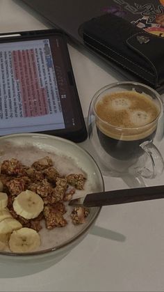 a bowl of cereal and bananas next to a tablet