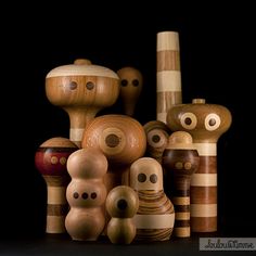 several wooden toys are stacked on top of each other in front of a black background