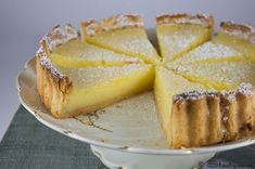 a lemon pie on a white plate with powdered sugar and sprinkles