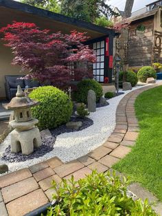 a small garden with rocks and plants in the front yard, next to a house