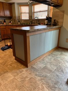 a kitchen with tile flooring and wooden cabinetry in it's center island