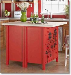 a kitchen with red painted cabinets and an island in front of the stove top oven