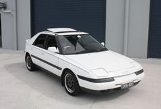 a white car parked in front of a garage