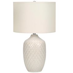 a white table lamp with a cream shade on it's base and a light bulb in the middle