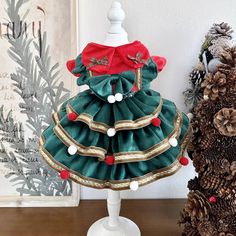 a green and red christmas dress sitting on top of a white mannequin head